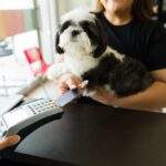 pet owner with dog pays veterinary bill