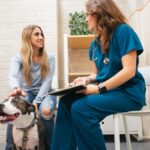 woman and her dog talk with a female veterinarian