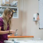 a young female veterinary technician in purple scrubs